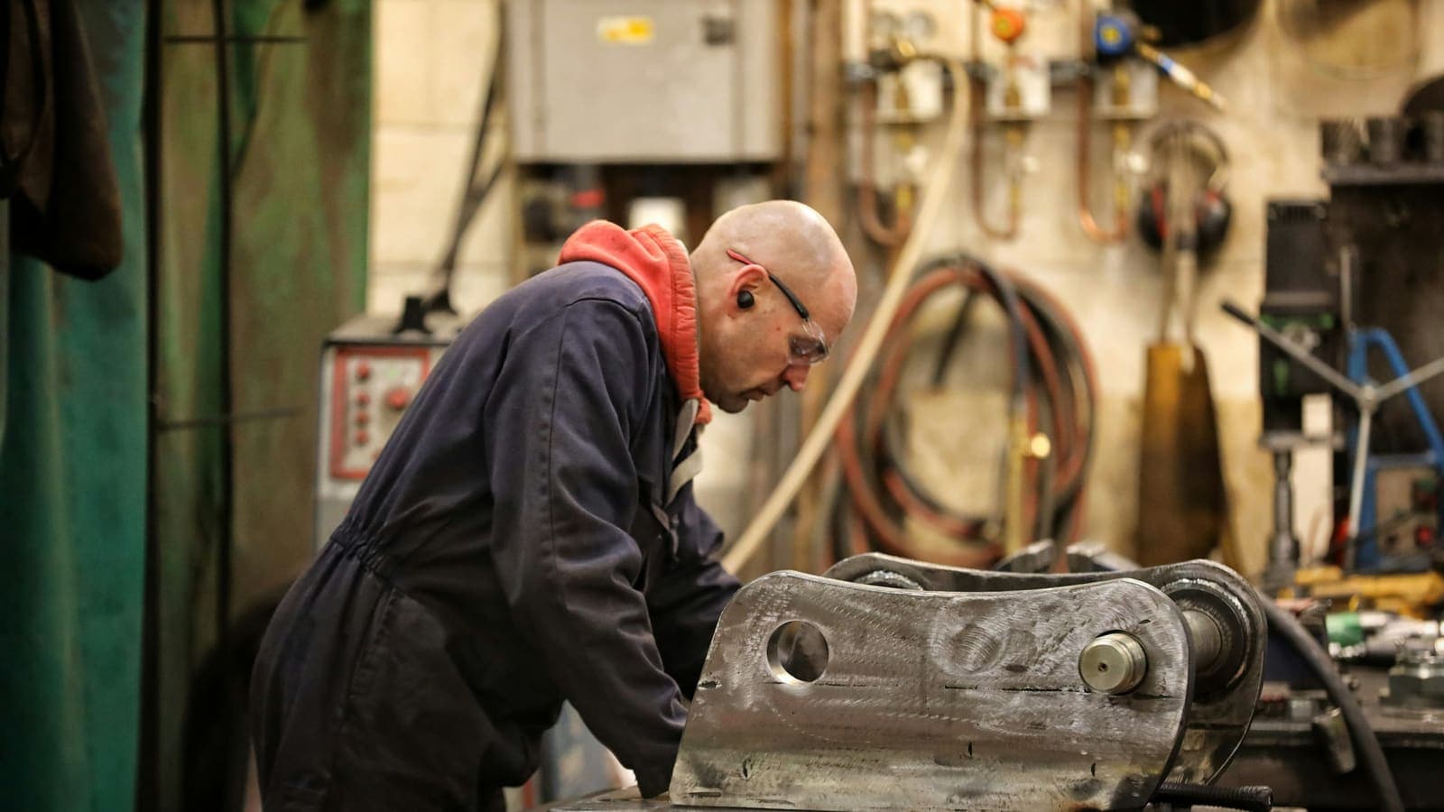Un technicien de maintenance travaille sur une pièce mécanique à l'atelier.
