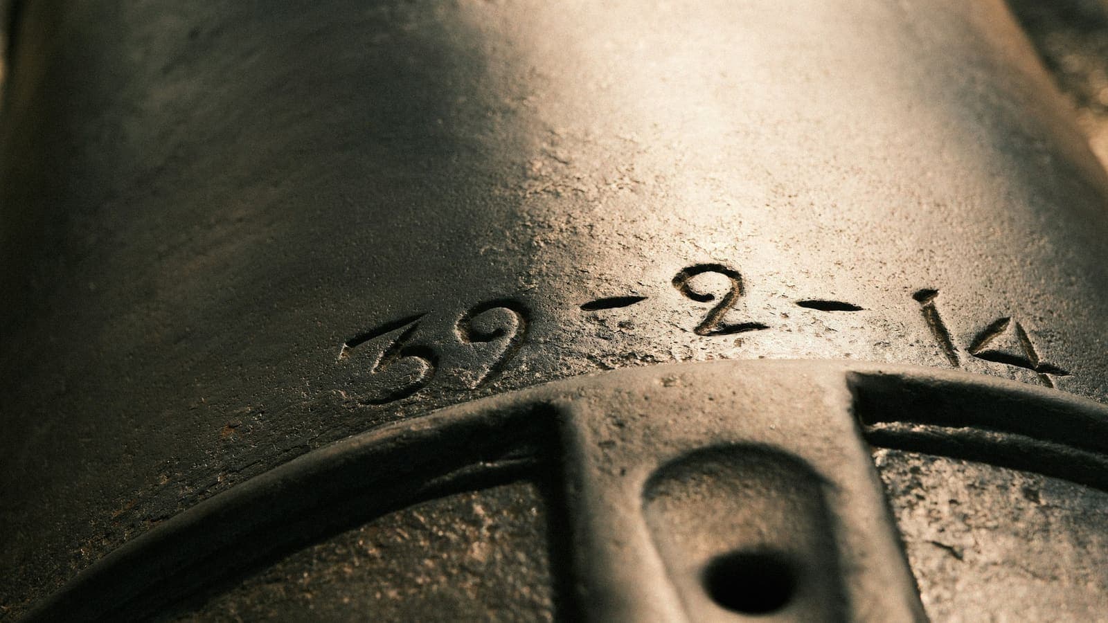 Un numéro gravé dans une pièce métallique : 39-2-14.
